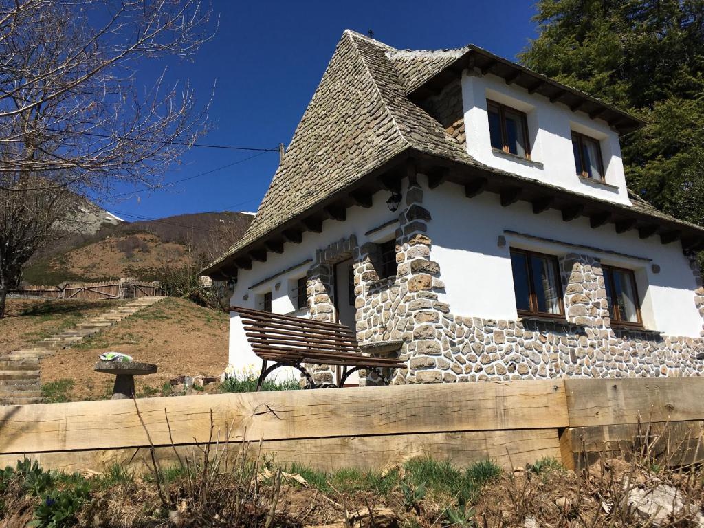 una casa con un banco delante de ella en Chalet Lou Griou, en Saint-Jacques-des-Blats