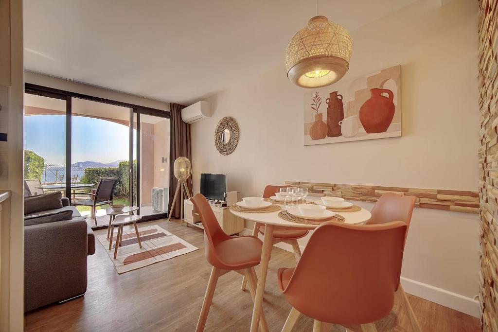 une salle à manger et un salon avec une table et des chaises dans l'établissement IMMOGROOM - sea view- Pool- Parking- garden, à Cannes