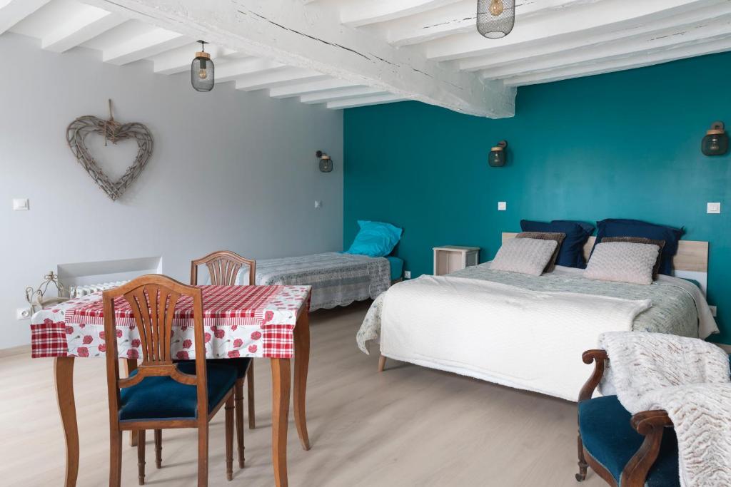 1 dormitorio con 2 camas, mesa y sillas en Chambre d hôtes en Montjavoult