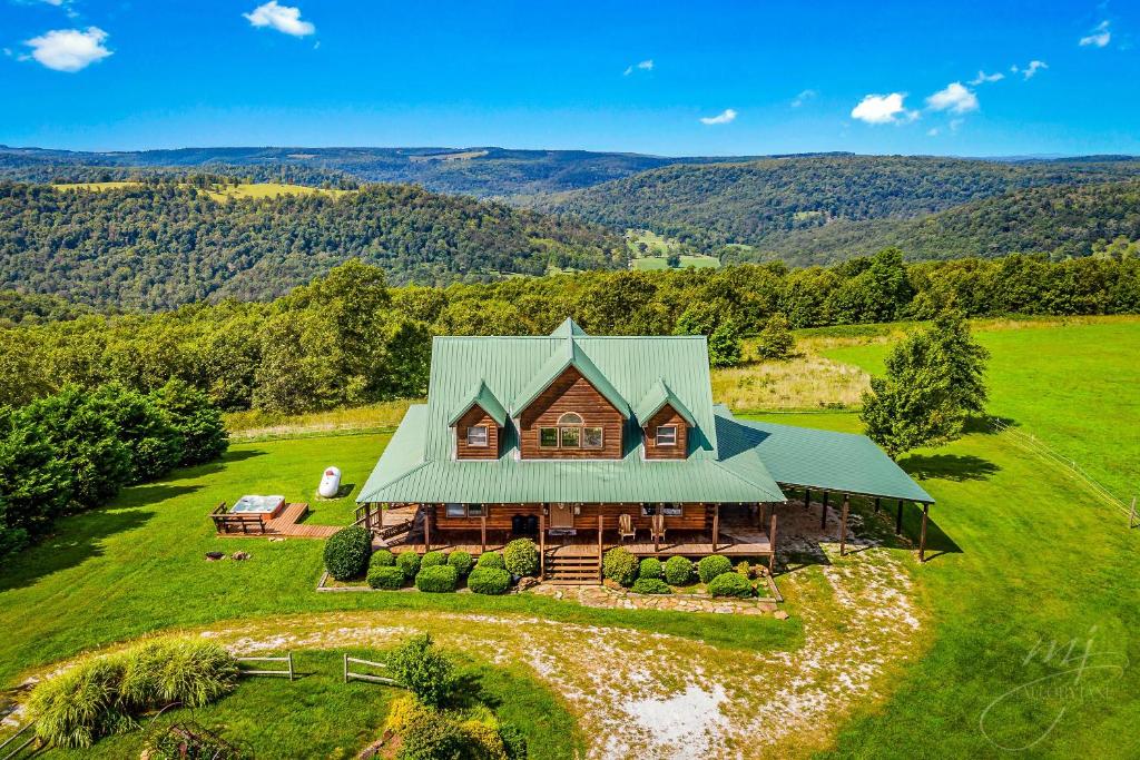 an aerial view of a house with a green roof at Lodge at OZK Ranch- Incredible mountaintop cabin with hot tub and views in Compton