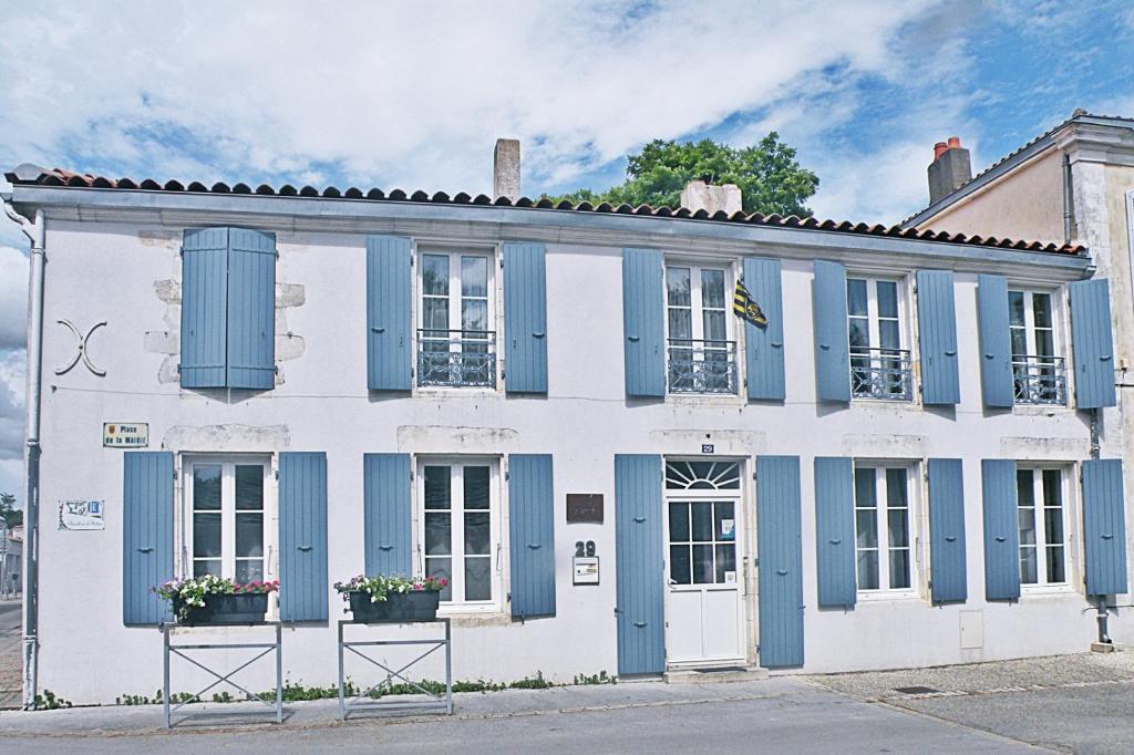 a white and blue building with blue shutters at L'Escale in La Jarrie