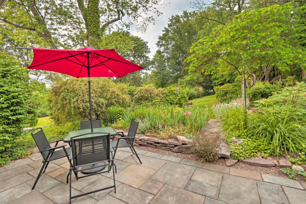 un tavolo e sedie con ombrellone rosso su un patio di Charming Abode with Patio - Walk to Town and River! a Stockton