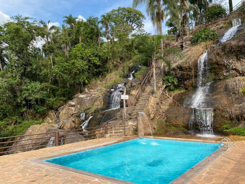 uma piscina com uma cascata ao fundo em Pousada Cachoeira Dos Sonhos em Serra Negra
