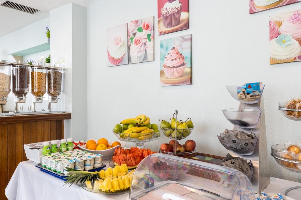 a table topped with bowls of fruit and desserts at Hotel Residencial Colibri in Costa da Caparica