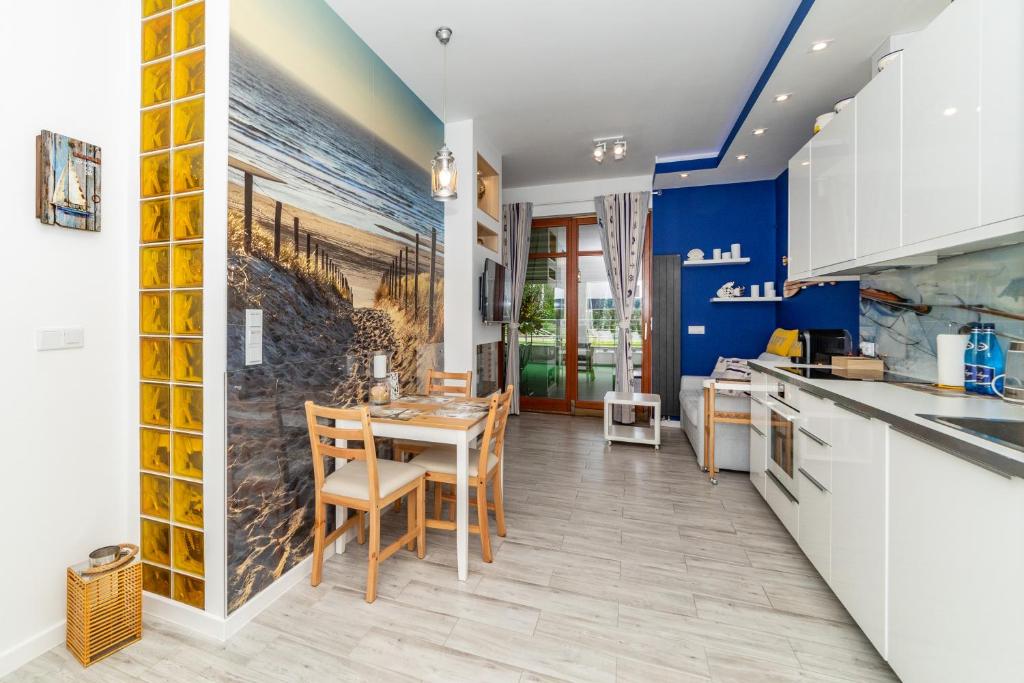 a kitchen with blue walls and a table and chairs at Luxury Yacht z tarasem - Neptun Park by OneApartments in Gdańsk