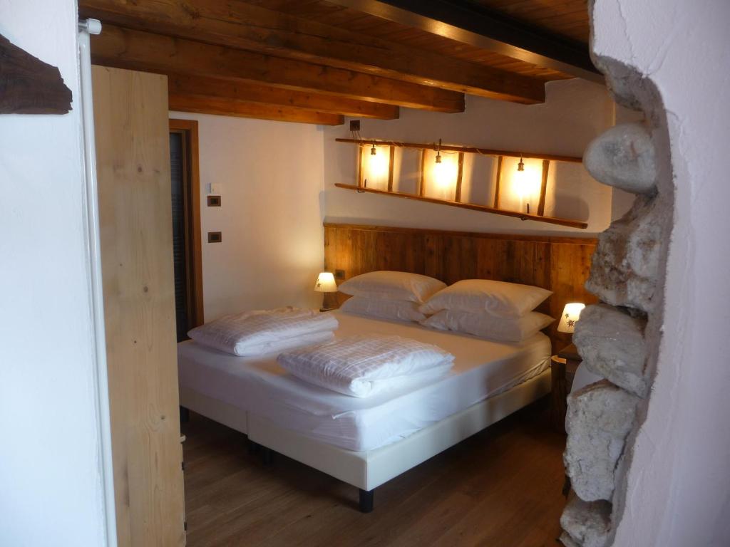 a bedroom with a bed with lights above it at BeB LUCA76 in Avise