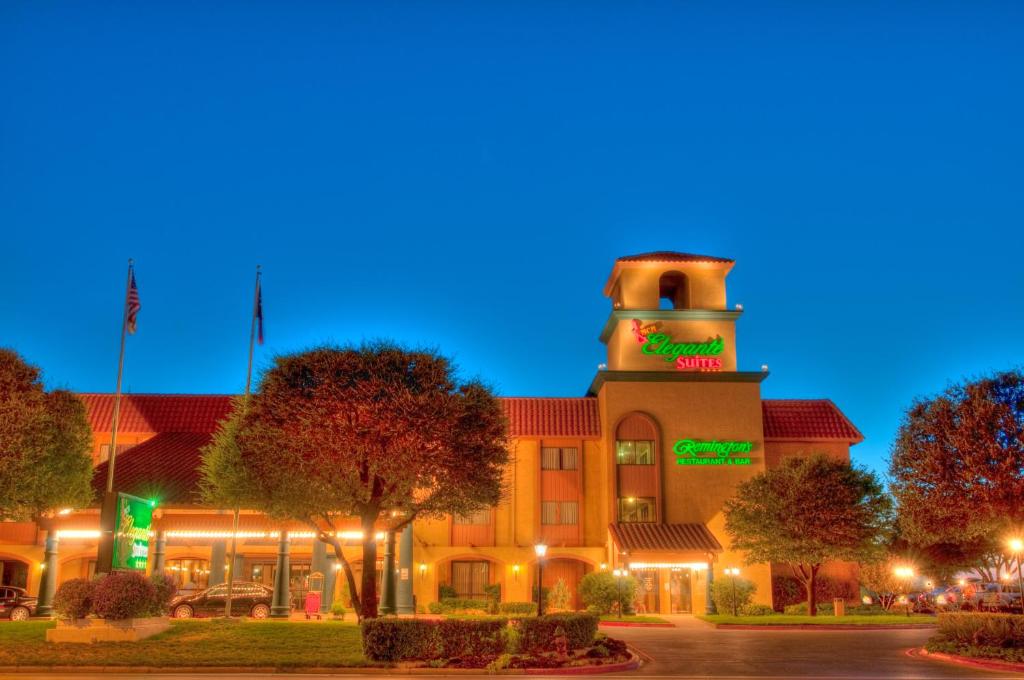 un edificio con una torre de reloj por la noche en MCM Elegante Suites Abilene, en Abilene