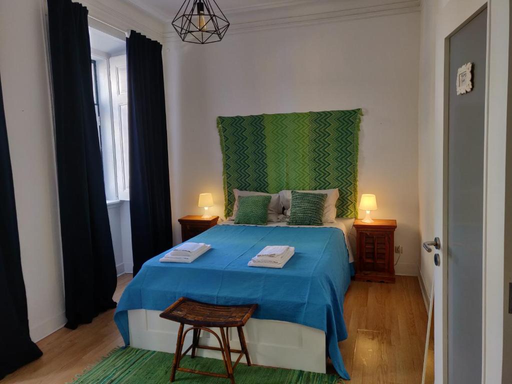Schlafzimmer mit einem blauen Bett und einem grünen Kopfteil in der Unterkunft Bhappy@home Lisboa in Lissabon