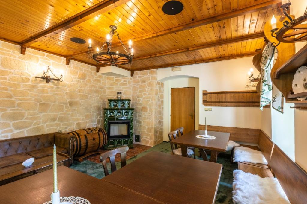 a room with wooden ceilings and tables and a fireplace at Pension Hubert in Raspenava