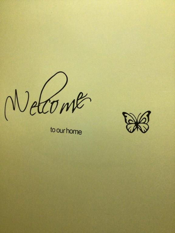 Un signe qui me souhaite la bienvenue chez nous avec un papillon dans l'établissement PORTA NUOVA, à Iglesias