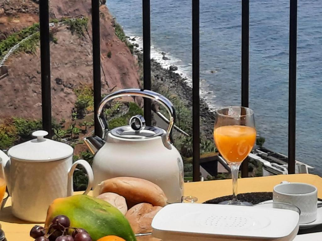 - une table avec de la nourriture et un verre de jus d'orange dans l'établissement Zeza´s Sky, à Calheta