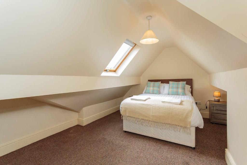 1 dormitorio en el ático con cama y ventana en Cherry Property - Coconut Suite en Blackpool