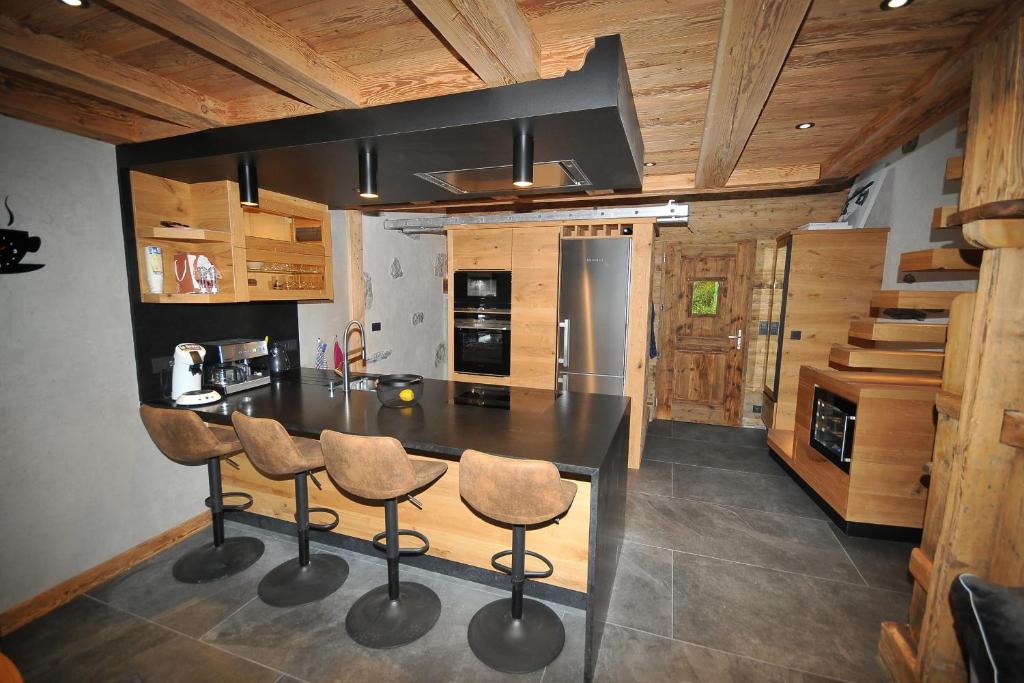 a kitchen with a black counter top and wooden ceilings at La cabane luxury apartment in the heart of the village in La Grave
