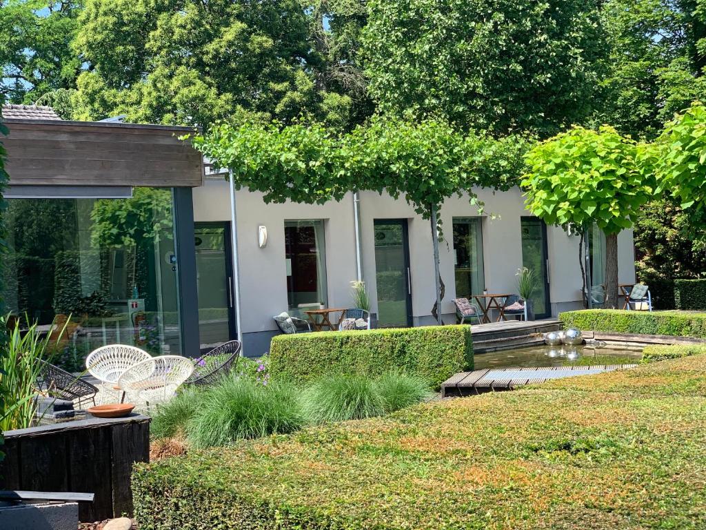 a garden with chairs and a house in the background at B&B Gusto in Halle