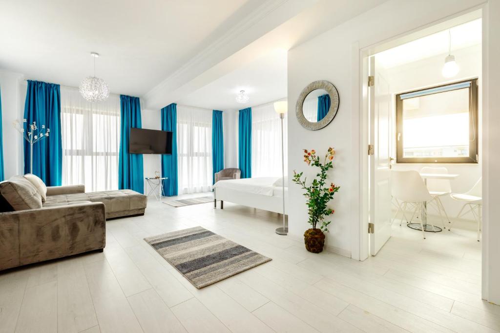 Una sala de estar con cortinas azules y un sofá. en North Club Apartments II, en Mamaia