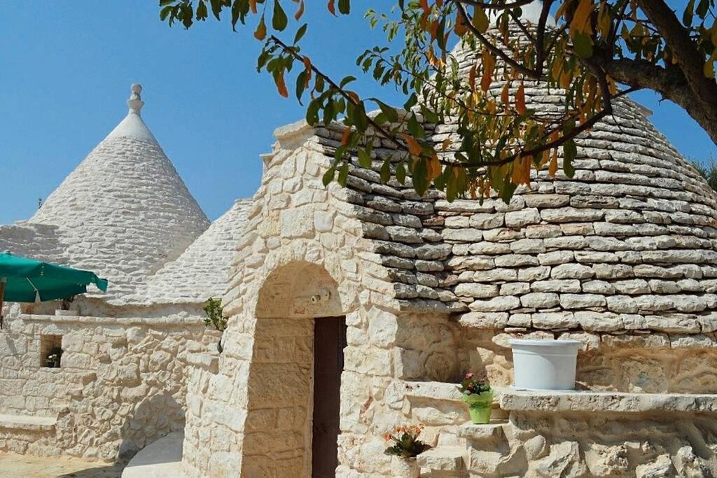 um edifício de pedra com duas pirâmides ao fundo em Trulli Monteforte em Villa Castelli