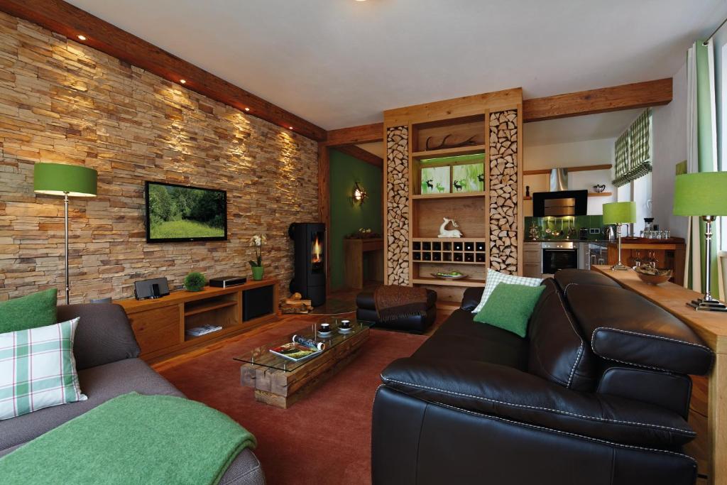 a living room with a leather couch and a brick wall at Apartments am alten Rathaus in Oberstdorf