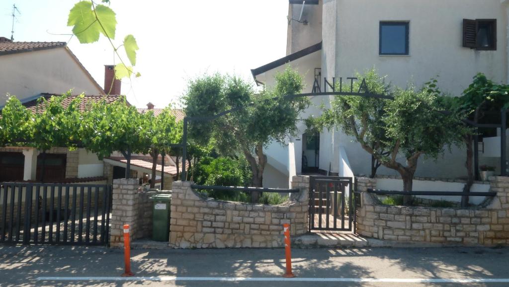 une clôture devant une maison arborée dans l'établissement Apartmani Anita, à Poreč