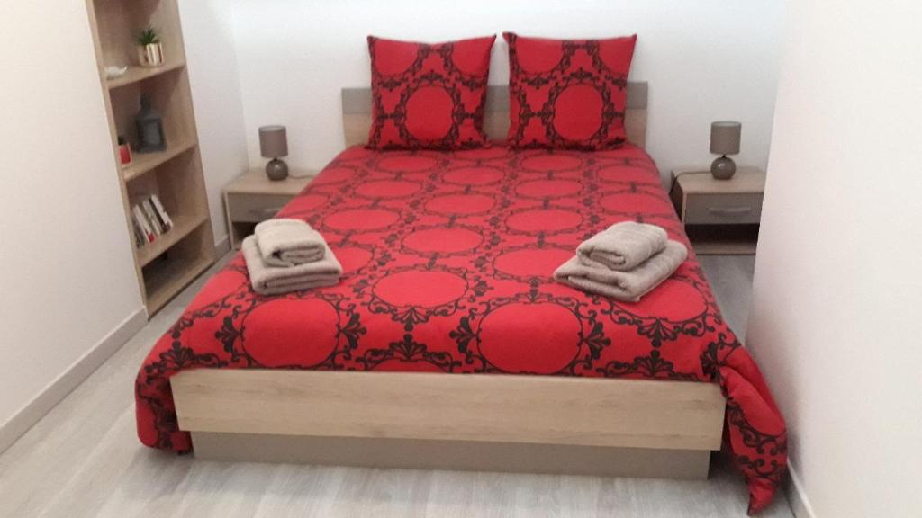 a bedroom with a red bed with red pillows at Maison au pays D' Aristide Bruand - Rose-Marie-Courtenay in Courtenay