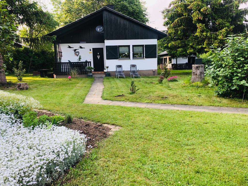 a small white house with a black roof at Sternenhimmel 2 in Thalfang