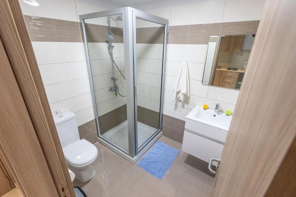 a bathroom with a shower and a toilet and a sink at Bellini Hotel in Ayia Napa
