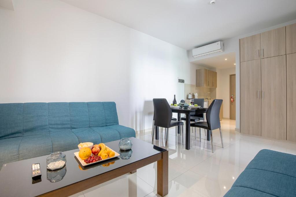 a living room with a blue couch and a table at Bellini Hotel in Ayia Napa