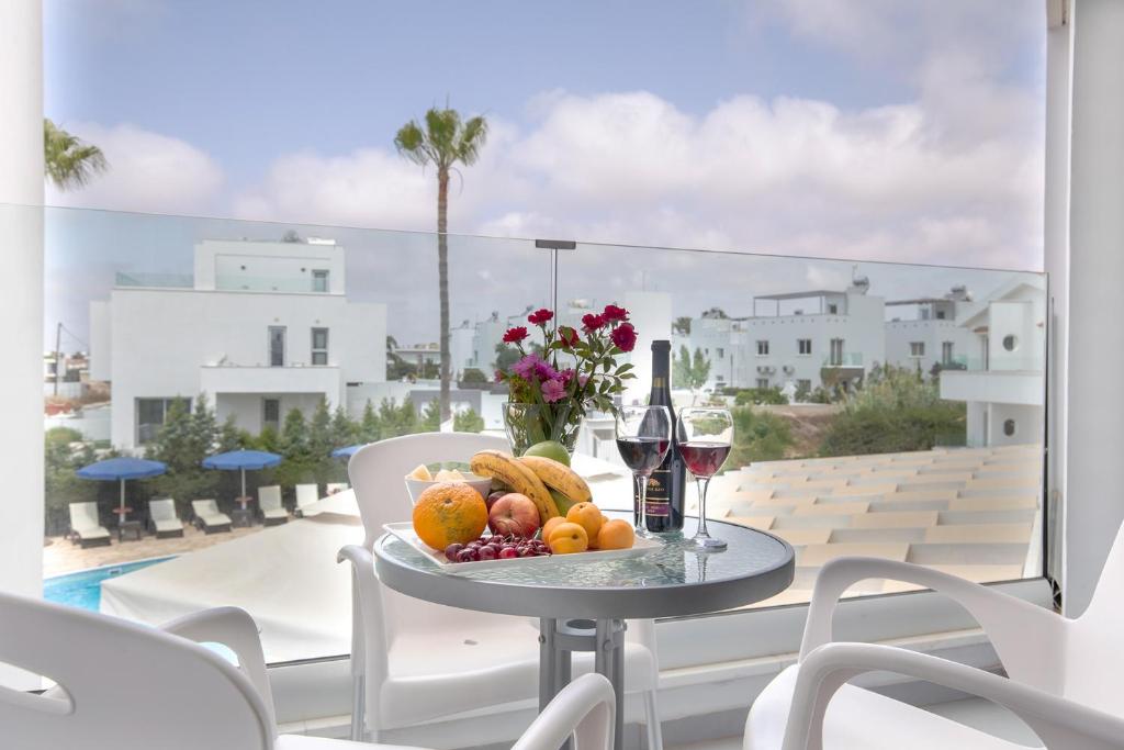a plate of fruit on a table on a balcony at Bellini Hotel in Ayia Napa