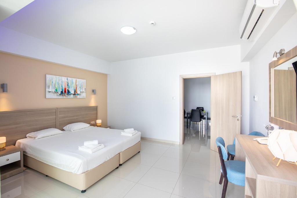 a bedroom with a bed and a table and chairs at Bellini Hotel in Ayia Napa