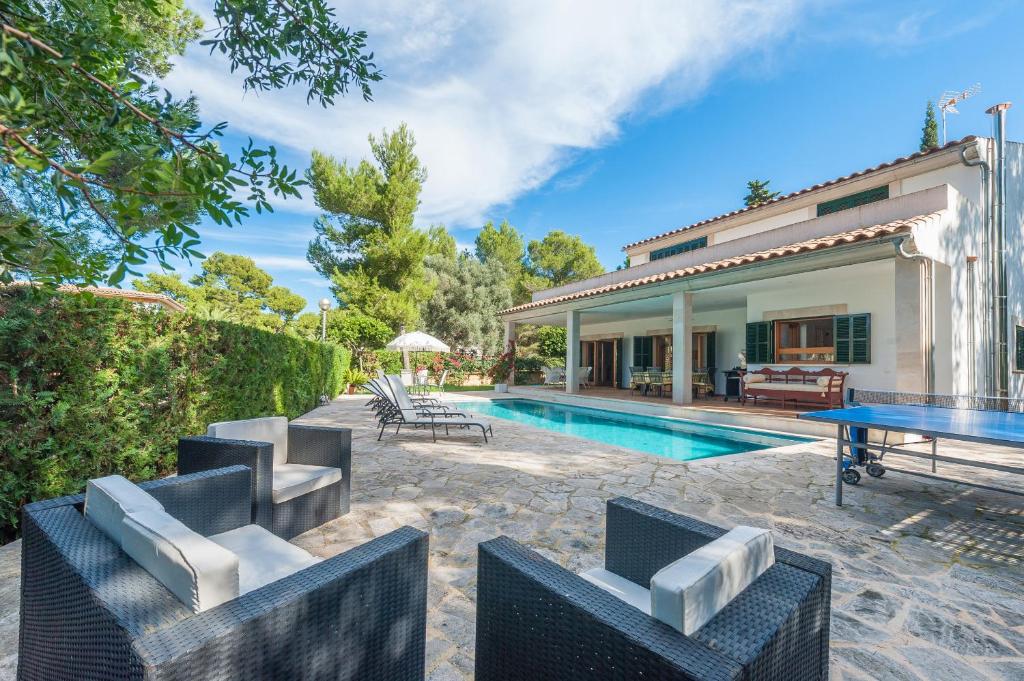 Cette maison dispose d'une piscine et d'une terrasse avec une table et des chaises. dans l'établissement Villa Es Bell Lloc, à Cielo de Bonaire 
