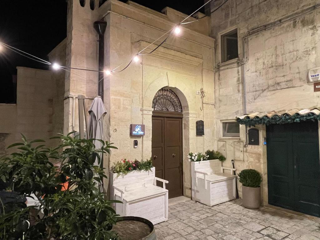Casa Adelina nel Centro dei Sassi في ماتيرا: مبنى فيه باب وبعض النباتات والانوار