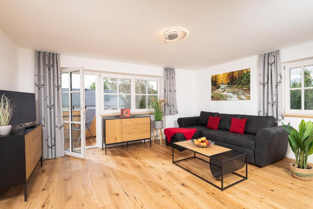 ein Wohnzimmer mit einem Sofa und einem Tisch in der Unterkunft "Haus 18" - Annehmlichkeiten von 4-Sterne Familien-und Wellnesshotel Viktoria können mitgenutzt werden in Oberstdorf