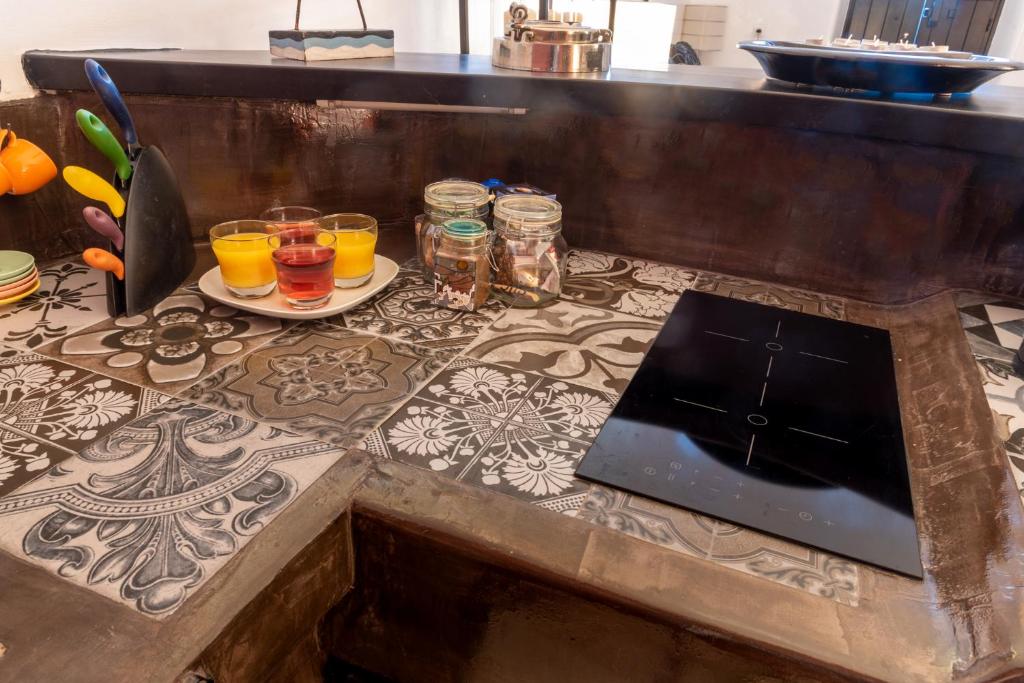 a counter with glasses of juice and a laptop on it at Villa Orpheus Santorini in Megalokhori