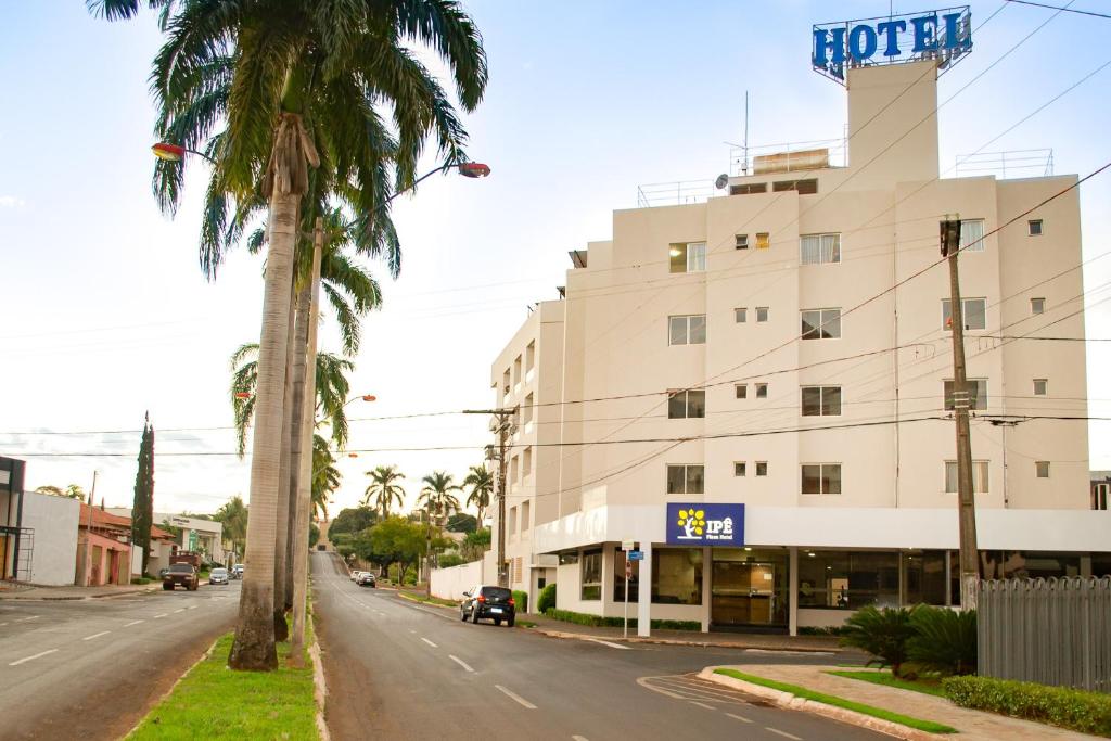a hotel on a street with a palm tree at IPÊ PLAZA HOTEL LTDA in Itumbiara