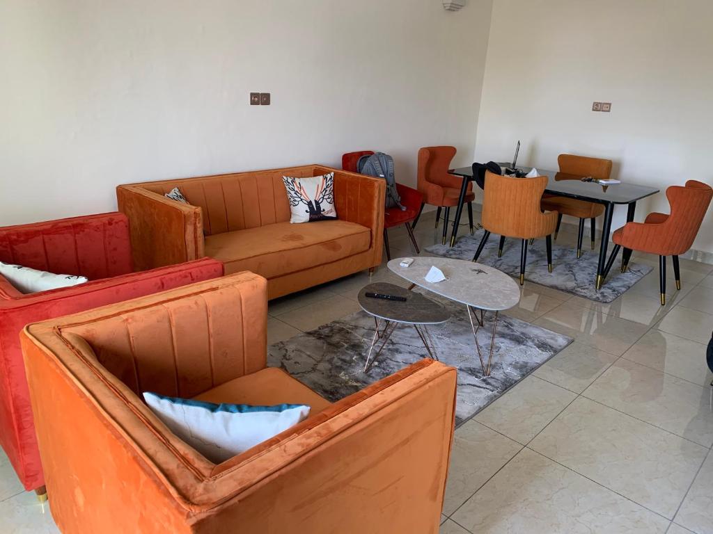 a living room with a couch and tables and chairs at Appartement chic et moderne in Douala