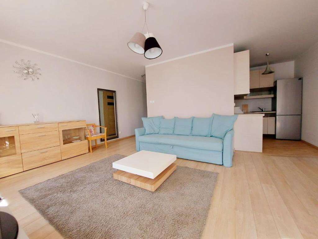 a living room with a blue couch and a table at Apartament Ania in Świnoujście
