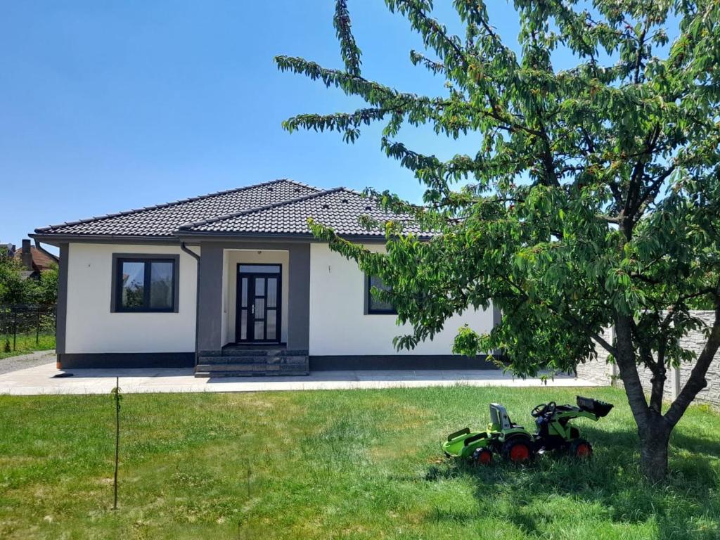 a small house with a motorcycle in the yard at CasaNova in Sînmartin