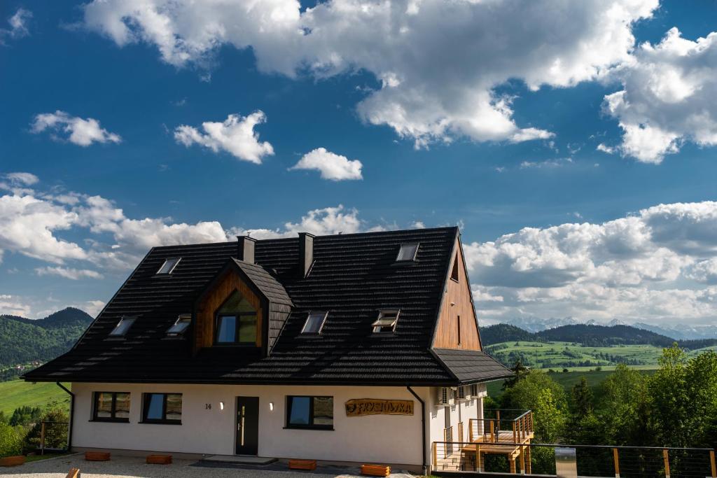 una casa con un techo negro encima en Krościenko Grywałd Czorsztyn Apartamenty Frysiówka, en Grywałd