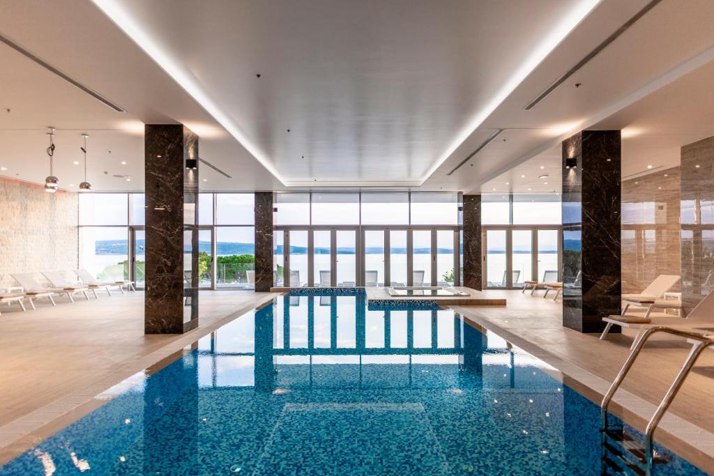 a pool in a building with a view of the ocean at Hotel Miramare in Crikvenica