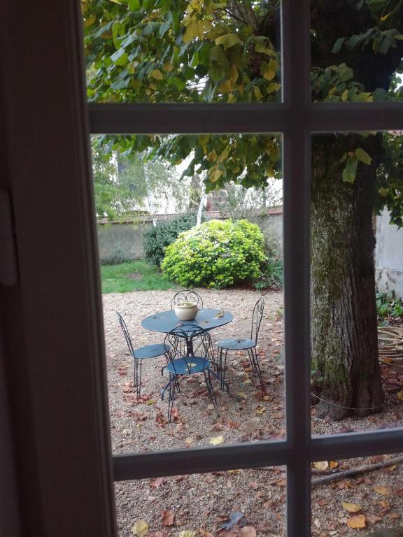 a view of a table and chairs from a window at Ancien Presbytère in La Chapelle-dʼAngillon