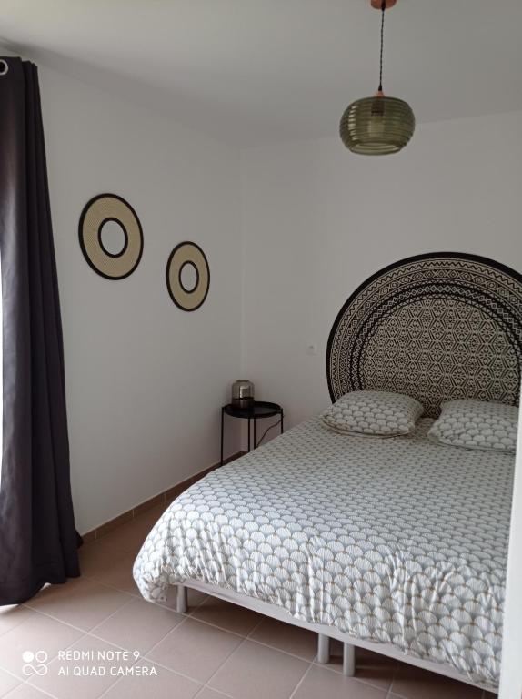 - une chambre avec un lit et 2 réveils sur le mur dans l&#39;établissement ferme de fenivou, à Boulieu-lès-Annonay