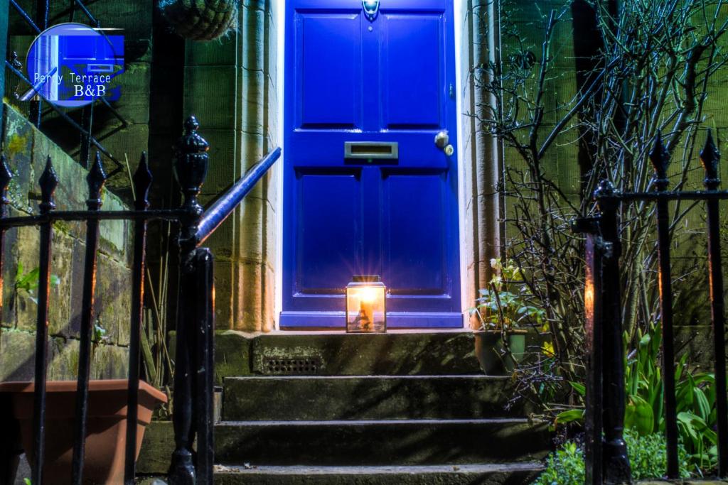a blue door with a candle on the stairs at Percy Terrace Bed and Breakfast in Alnwick