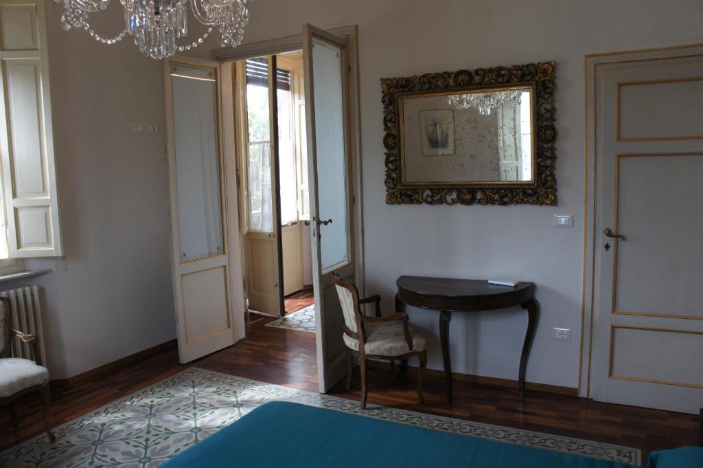 Zimmer mit einem Tisch, einem Stuhl und einem Spiegel in der Unterkunft Villa Magnolia Park in Pisa