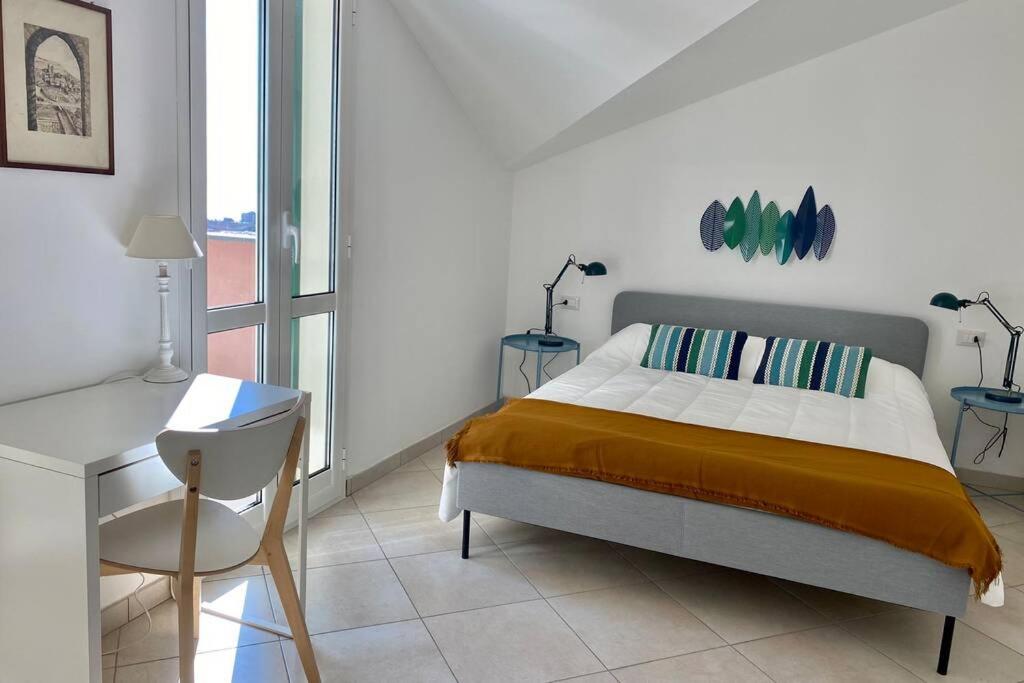 1 dormitorio con cama, escritorio y silla en Terrazza Vista Mare, en Borgio Verezzi