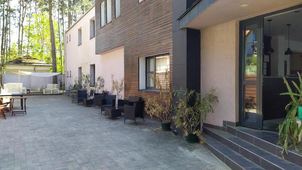 patio z krzesłami i stołem oraz budynek w obiekcie VilLa AdeLe w Siófoku