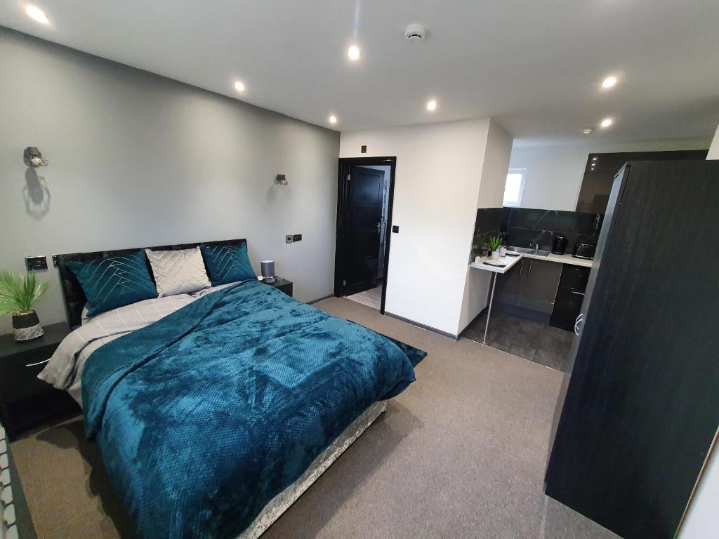 a bedroom with a large bed with a blue blanket at Oxclose studios in Peterborough