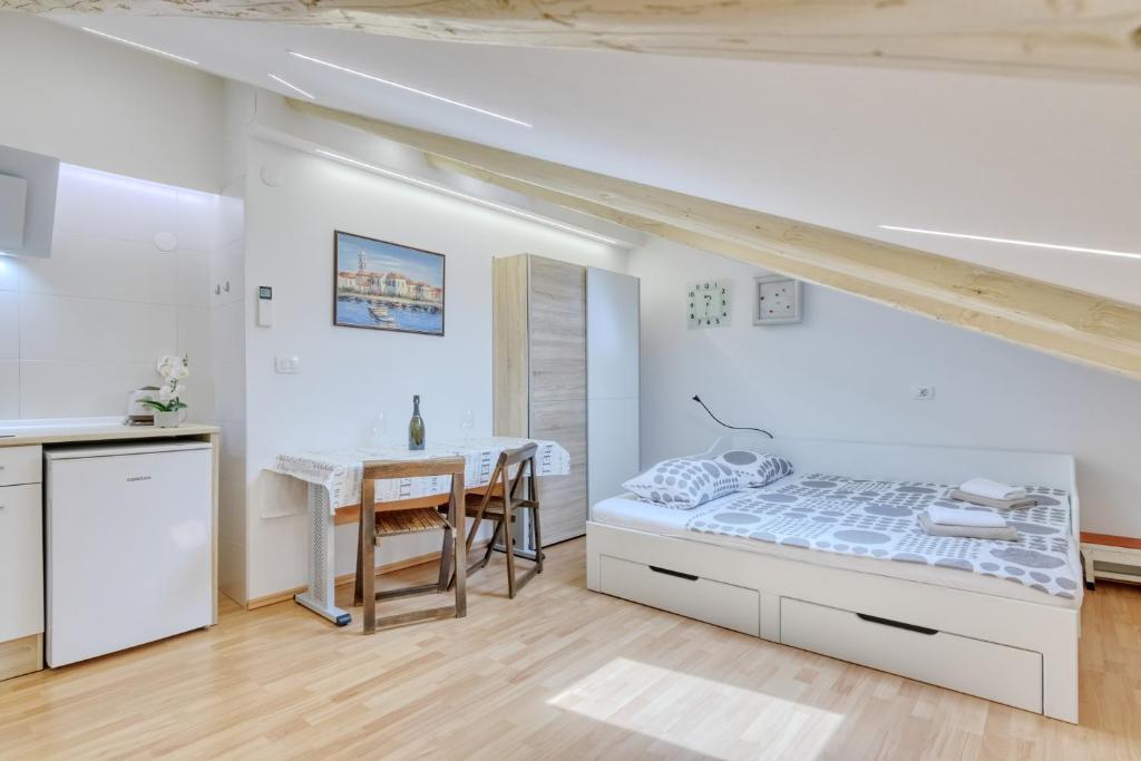 a white bedroom with a bed and a table at Apartment light in Pula in Pula