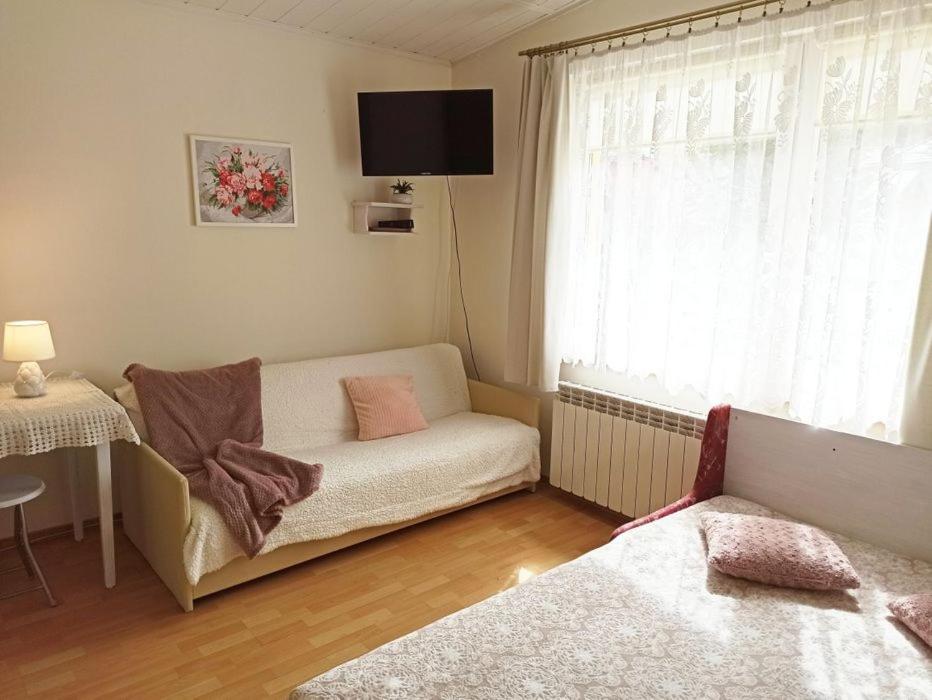 a living room with a couch and a window at Domek wypoczynkowy Szczyrk Centrum - Twój Domek in Szczyrk