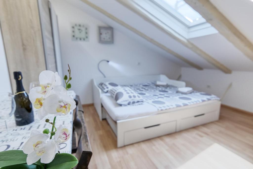 a bedroom with a bed and a table with flowers at Apartment light in Pula in Pula