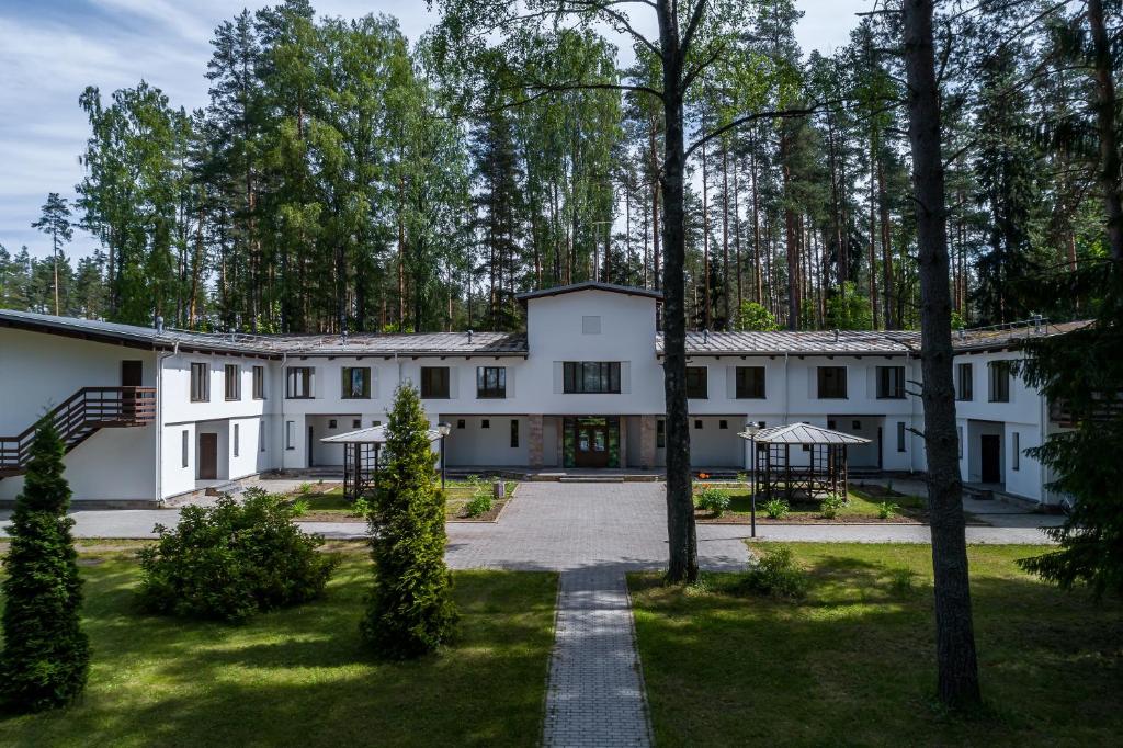an exterior view of a white building with trees at Курортный отель "Архитектура здоровья" in Zelenogorsk