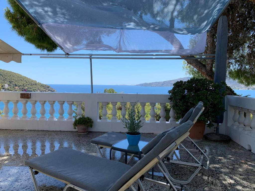 a patio with two chairs and a table and a fence at Villa Loula Apartment II in Poros
